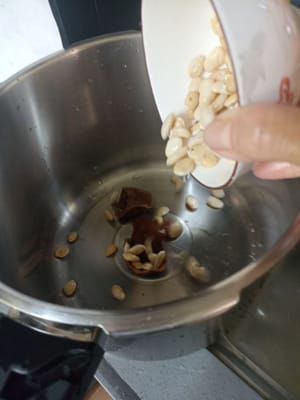 Kerne und Orangenschale in die Pfanne geben.