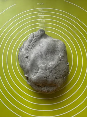 Letakkan adonan wijen hitam yang sudah didiamkan di atas alas penggiling.