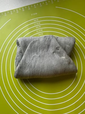 Balik adonan dan lipat bagian atas dan bawah ke tengah seperti yang ditunjukkan.