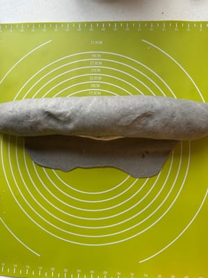 Mulailah menggulung adonan dari atas ke bawah hingga mencapai tepi.