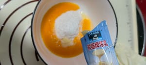 Batir dos yemas de huevo, añadir 45 gramos de coco rallado y añadir un tubo de leche condensada para realzar el sabor y eliminar el olor a pescado.