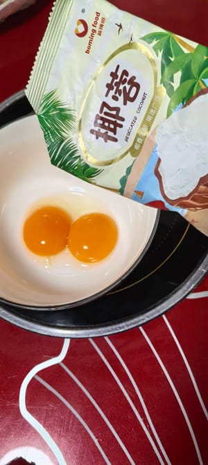 两个蛋黄打散加45克椰蓉，加一条炼乳去增香去腥。