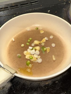 先用熱油將蔥花和蒜蓉炒2分鐘。然後加入碎辣椒，拌勻。