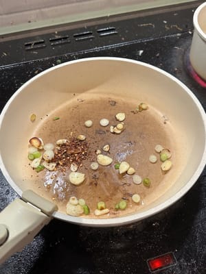 先用熱油將蔥花和蒜蓉炒2分鐘。然後加入碎辣椒，拌勻。