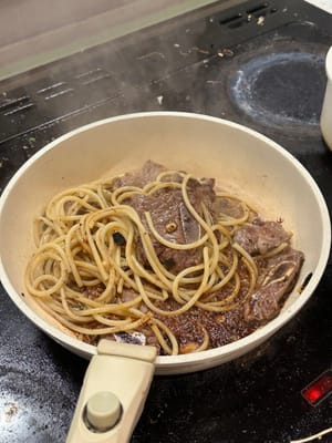 將意大利粉和牛小排翻炒，加入醬汁和少許（約10毫升）煮麵水。繼續攪拌義面，直到醬汁變得濃稠。