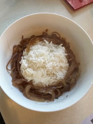 Zuerst die Zwiebeln um den Reis in einer Schüssel anordnen.