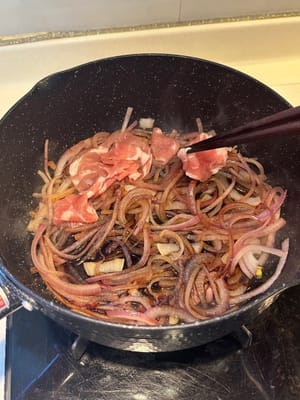 Anschließend die Rindfleischscheiben zu den Zwiebeln geben.