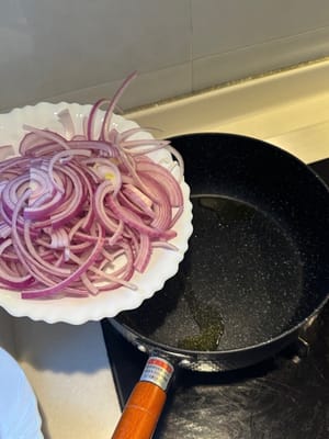 Zwiebeln in einer erhitzten Pfanne mit Öl bei mittlerer Hitze anbraten, bis sie weich sind.