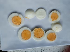 Tagliare a pezzi le due uova sode e metterle su un piatto per utilizzarle in seguito.