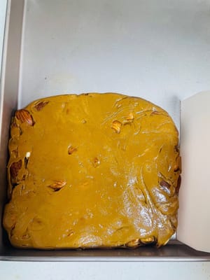 整形:
把拌好的糖倒回那個從焗爐裡拿出焗盤裡,用板子快速壓平。要是焗盤不保溫,糖一碰到冷的地方馬上就硬了,根本壓不動。