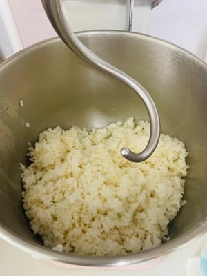 攪糯米飯
1. 千萬別用手直接揉，燙！把蒸好的糯米飯趁熱（才有黏性，冷了會硬）快速倒進廚師機的攪拌桶 ，裝上揉麵鉤，開低速檔攪。
~要是冇廚師機，就找個耐熱的大容器，用擀麵棍之類的工具，別讓手直接接觸燙糯米！會燙會粘，會燙到爪子（手）甩都甩不掉😂
不管機器還是手動，都得使勁兒攪個6–8分鐘左右，直到糯米飯變得黏糊糊、有韌性，攪著越嚟越費勁兒，就成啦！手動的，這時候手臂酸也值，好吃的在招手！