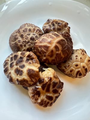 Die eingeweichten Shiitake-Pilze halbieren und in kleine Stücke schneiden.