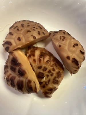 Die eingeweichten Shiitake-Pilze halbieren und in kleine Stücke schneiden.