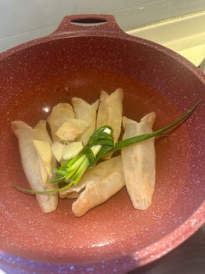 Die Fischblase mit Ingwer, Frühlingszwiebeln und Kochwein 10 Minuten blanchieren. Anschließend sofort mit kaltem Wasser abspülen.