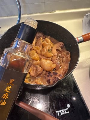 Die Sauce zugedeckt bei starker Hitze einkochen lassen, dann Sesamöl für das Aroma hinzufügen.