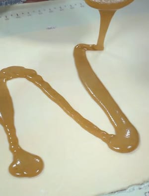 把备好的油酥倒在面片上涂抹均匀。