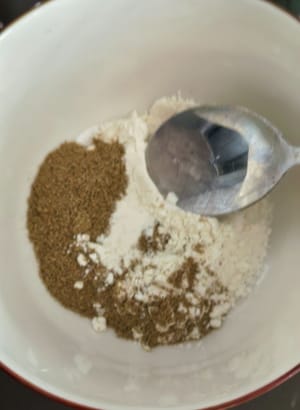 Campurkan dua sendok teh tepung terigu dengan satu sendok teh garam dan merica, tuang dua sendok teh minyak panas di atasnya, aduk rata.