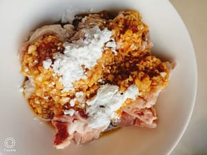 Anschließend die pürierte Knoblauchsauce über die Rippchen gießen, zwei Teelöffel Stärke dazugeben und mit den Händen gut vermengen.