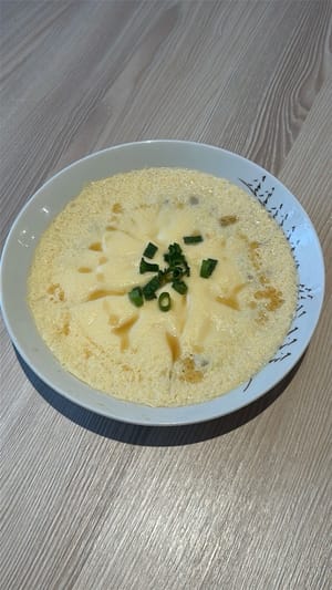 Once the egg is set, drizzle sesame oil and garnish with green onion