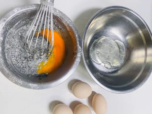 分离蛋清、蛋黄：将5个蛋黄打入黑芝麻糊的盆里。蛋清打入准备好的打发蛋清盘（切记无油无水）。
