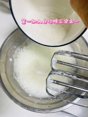 Ajoutez les 50 grammes restants de sucre blanc en trois fois et battez jusqu'à ce que le crochet se forme.