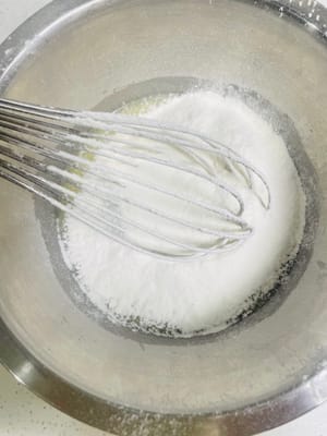 Tamisez ensuite la farine à faible teneur en gluten en forme de Z dans un bol et mélangez jusqu'à ce qu'il n'y ait plus de particules. Ne jamais remuer en rond, sinon la pâte deviendra glutineuse.
