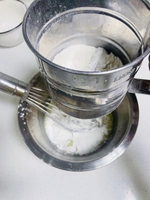 Tamisez ensuite la farine à faible teneur en gluten en forme de Z dans un bol et mélangez jusqu'à ce qu'il n'y ait plus de particules. Ne jamais remuer en rond, sinon la pâte deviendra glutineuse.