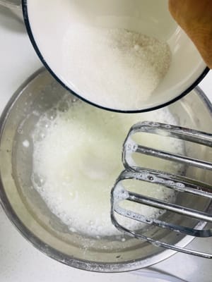 Monter les blancs en neige : Ajouter 5 gouttes de jus de citron puis ajouter la fécule de maïs pour éviter les éclaboussures de poudre lors de la mise en marche du fouet. Remuez d'abord manuellement quelques fois, puis allumez le fouet à grande vitesse pour battre jusqu'à ce que de grosses bulles se forment.