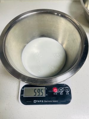 用准备好的蛋黄糊盆称好约60克牛奶。
