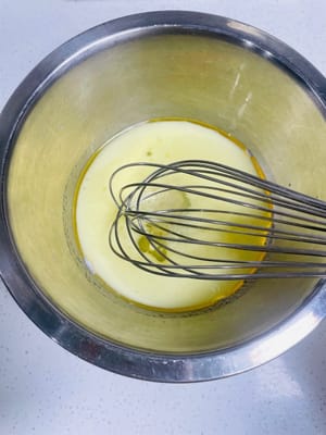 Ajoutez 50 grammes d’huile de maïs et 20 grammes de sucre blanc dans le bol de lait et mélangez bien.