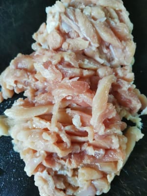Das Hähnchenfleisch gründlich waschen, anschließend mit einem Küchentuch trockentupfen und in dünne Scheiben schneiden.