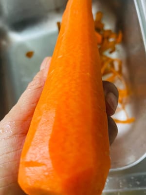 Pelar las zanahorias y cortarlas en trozos para utilizarlas más tarde.