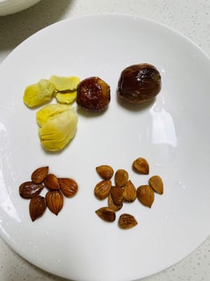 Siapkan irisan jahe, kurma manisan, dan kacang almond.
