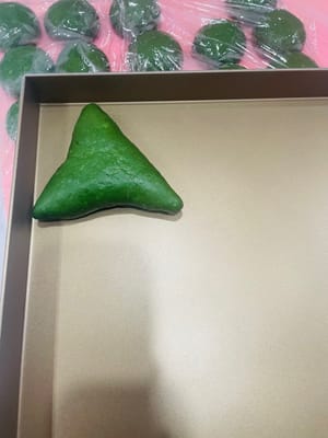 (2) Füllen und Formen: Nehmen Sie einen lockeren Teigball, drücken Sie ihn mit der Handfläche flach und rollen Sie ihn zu einem Kreis aus. Geben Sie die Mochi-Füllung und die gehackten Nüsse in die Mitte und drücken Sie die Öffnung von einem Ende zur Mitte hin fest zusammen (drücken Sie mehrmals, damit die Füllung beim Backen nicht ausläuft). Alternativ können Sie den Teig auch nach Belieben formen.

Tipp: Falls Sie nicht wissen, wie man rollt oder faltet, schauen Sie sich einfach das Video an, das ich gepostet habe; die Schritte sind ganz einfach!