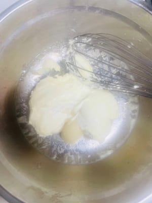 Nach dem Abkühlen Butter und glatten Frischkäse hinzufügen und gut verkneten, bis alles gut vermischt ist.