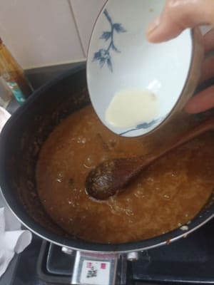 Après cela, la sauce devient un peu liquide, j'ajoute donc un peu d'épaississant, je remue une minute et j'éteins le feu. Je fais cuire cette sauce satay pendant 20 minutes, à feu doux dès le début. Je l'ajoute à feu doux dans la minute qui suit.