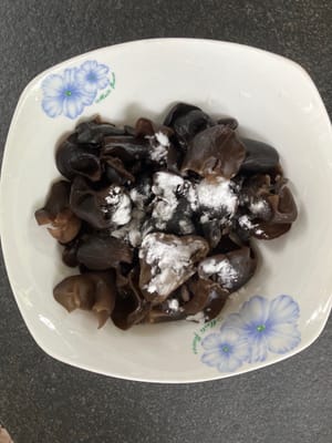 After 20 minutes drain the fungus, add flour & mixed thoroughly to remove dirt still attached to the fungus. Wash a few times drain & discard the water.