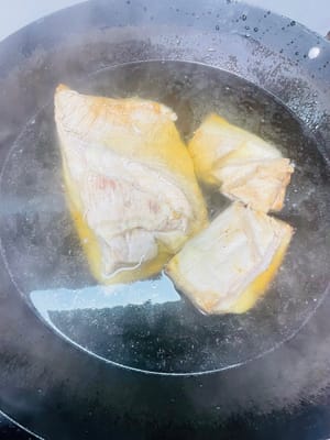 Mettere la pancetta di maiale fritta in acqua calda, lasciando in ammollo solo la parte della pelle, per mezz'ora, finché la pelle non galleggia in superficie, diventando più morbida e tenera.