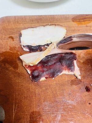 Distribuire uniformemente la pasta di fagioli rossi al centro di ogni fetta di carne ancora attaccata al taglio.