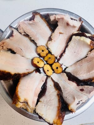 Ungere l'interno della ciotola per la cottura a vapore con lo strutto, disporre le fette di carne con il ripieno di sabbia, con la pelle rivolta verso il basso, ordinatamente lungo il bordo della ciotola, quindi spalmare sopra il composto di zucchero di canna e riso glutinoso.