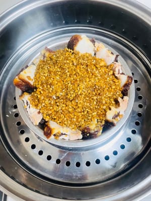 Mettere la ciotola per la cottura a vapore in una vaporiera e cuocere a vapore sopra l'acqua. Dopo che l'acqua bolle, abbassare la fiamma e cuocere a vapore per 2 ore e mezza, finché la carne e il riso glutinoso non saranno morbidi, appiccicosi e saporiti.