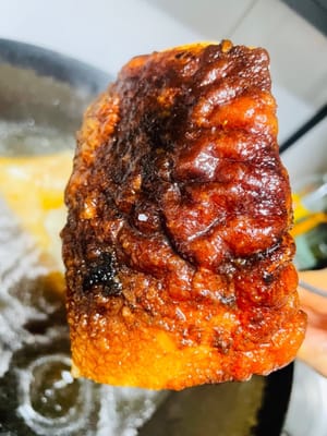 Mettere la pancetta di maiale fritta in acqua calda, lasciando in ammollo solo la parte della pelle, per mezz'ora, finché la pelle non galleggia in superficie, diventando più morbida e tenera.