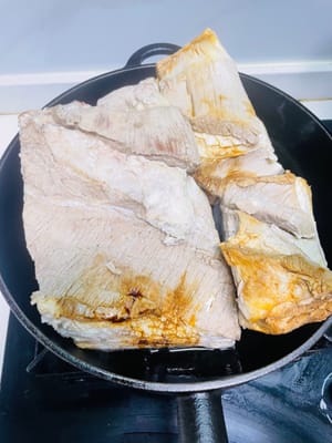 Versare una quantità adeguata di olio in una padella, posizionare la carne di maiale con la cotenna rivolta verso il basso e friggere. Coprire la padella durante tutta la cottura per evitare schizzi di olio. Spegnere il fuoco e attendere che la frittura si concluda prima di aprire il coperchio per controllare. Friggere fino a quando la cotenna non sarà dorata.