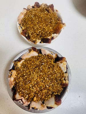 Ungere l'interno della ciotola per la cottura a vapore con lo strutto, disporre le fette di carne con il ripieno di sabbia, con la pelle rivolta verso il basso, ordinatamente lungo il bordo della ciotola, quindi spalmare sopra il composto di zucchero di canna e riso glutinoso.