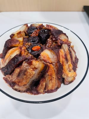 Dopo la cottura a vapore, capovolgere il piatto su un piatto, guarnire con datteri rossi e bacche di goji, aggiungere la pancetta di maiale dolce e tenera e la saporita pancetta di maiale brasata, salata e saporita, ricca ma non unta, è super deliziosa!