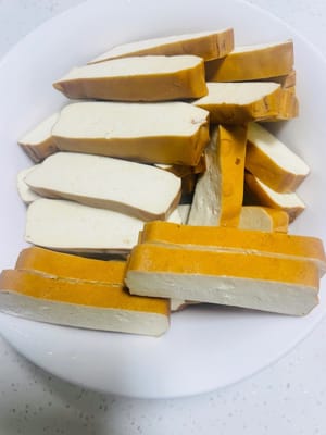 Wash the Youxian dried tofu and cut it into slices about 3mm thick. Make sure the thickness is even so that they are heated evenly when stir-frying.