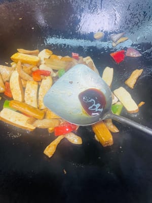 把之前炒好的豬肉倒回鍋裡，加入 1 匙生抽、1 匙蠔油，翻炒均勻，讓每塊肉和香乾都裹上醬汁，最後放入蔥段，翻炒幾下提提香，就可以裝盤啦 。