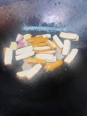 鍋裡留少許底油，放入料頭（大蒜、薑片、洋蔥 ），開小火慢慢爆香，炒到洋蔥變軟、香味出嚟，再倒入青紅彩椒塊，轉中火翻炒至彩椒微微變軟 。