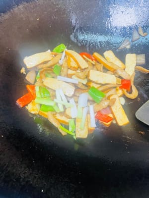 Pour the previously fried pork back into the pot, add 1 spoon of soy sauce and 1 spoon of oyster sauce, stir-fry evenly so that every piece of meat and dried tofu is coated with the sauce, finally add the scallion segments, stir-fry a few times to enhance the flavor, and then you can serve.