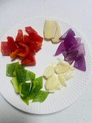 Smash the garlic, slice the ginger, wash and cut the green and red peppers into small pieces, peel the onion and cut into small pieces for later use.